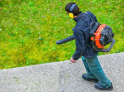 A gardener using a leaf blower